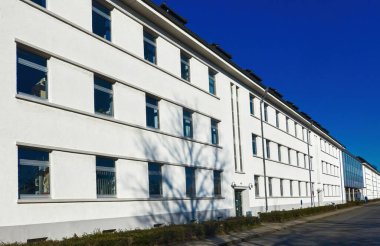 A large white building with windows on blue sky background