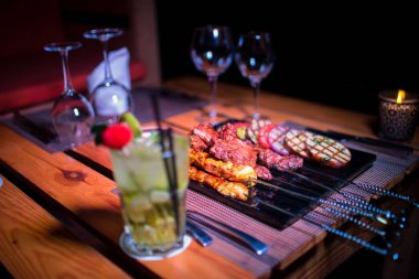 Bir tabak tavuk ve sığır barbeküsü yanında da bir bardak taze mojito.