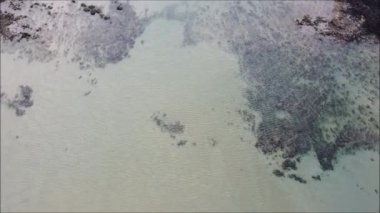 An aerial view of the ocean waves hitting the rocky beach at the Alagamar Beach, Natal, Rio Grande do Norte, Brazil