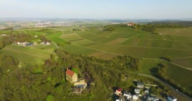 Almanya 'da bir eğlence parkının yanında arka planda üzüm bağları olan eski bir kale.