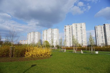 A view of high apartment blocks by a green grass field in the Orla Bialego district