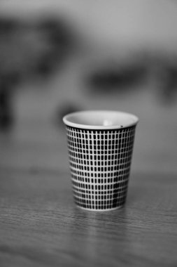 Üzerinde siyah çizgiler olan küçük bir bardağın dikey görüntüsü.