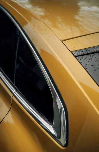 雨の後の黄色の車の後部四分の一パネルの垂直ショット — ストック写真
