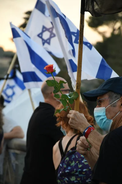 イスラエルのエルサレムで抗議中に赤いバラを持った衛生マスクをした老人が — ストック写真