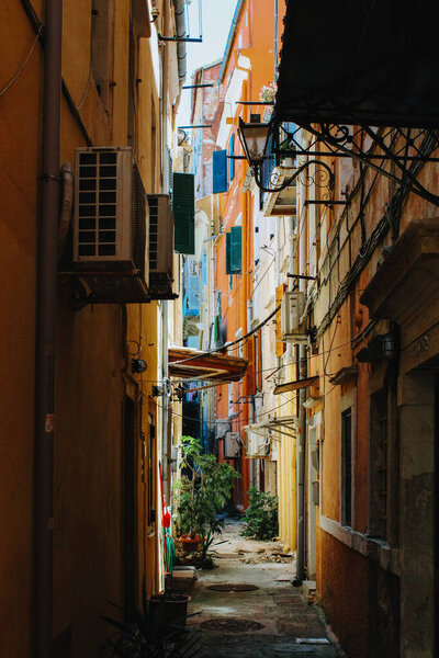 A vertical shot of small narrow street on the island of Corfu with a summer day