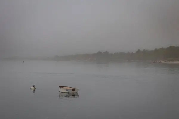 朝の霧の中で湖の中の木製のボートの景色 — ストック写真