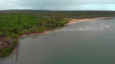 An aerial view of a small island in the turquoise sea in summer