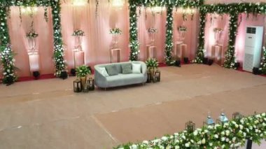 An aerial slow movement around decorated wedding hall with chair for married people