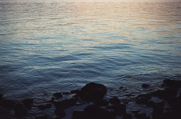 Malebný Pohled Oceánské Vlny Odrážející Krásný Západ Slunce Skalnatou Pláž — Stock fotografie