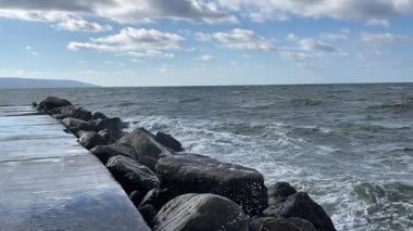 Slow-motion of waves crashing on the stone of a beach