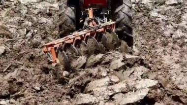 A tractor plowing the land in daylight