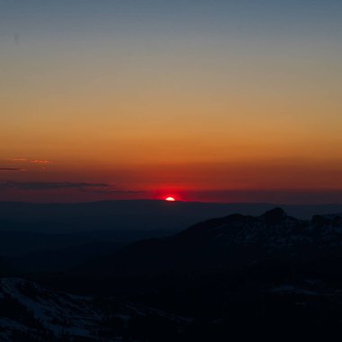 Gün batımında dağların üzerinden renkli bir cennet manzarası