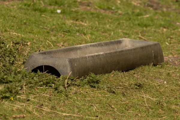 Galvanised metal animal water trough in grass field