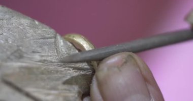 Jakarta, Indonesia-June 19, 2022: a traditional goldsmith forms a ring with a hone