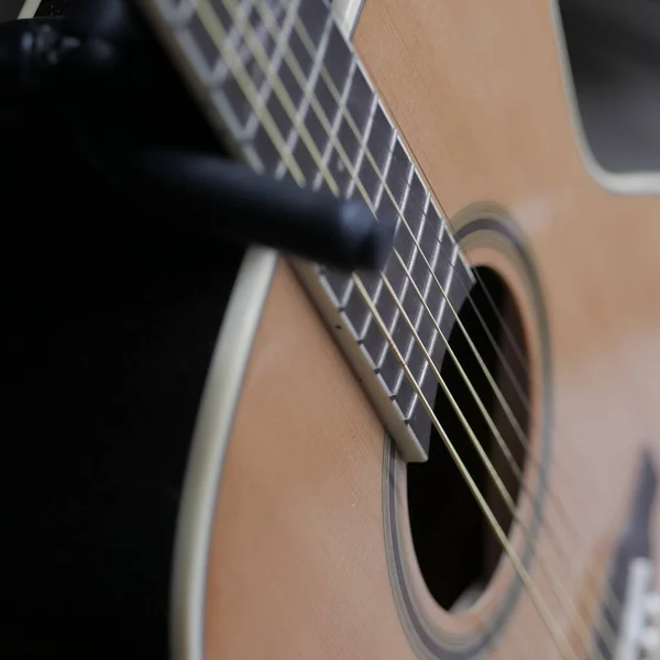 背景がぼやけて明るい光の中で茶色のクラシックギターのクローズアップショット — ストック写真