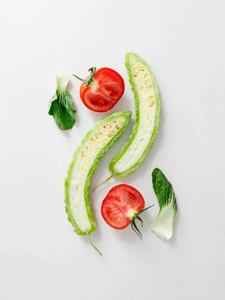 Een Bovenaanzicht Van Gesneden Tomaat Bittere Kalebas Sla Witte Achtergrond — Stockfoto