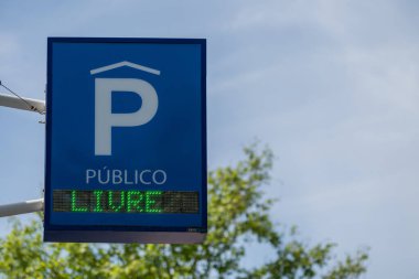 Otopark binasının dışında aydınlık bir park yeri tabelası.