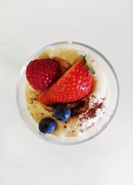 Krema ve böğürtlenli bir tatlı manzarası.