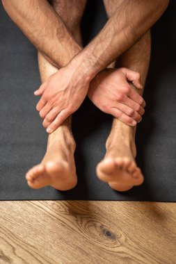 Yoga yaparken insan bacakları ve ellerinin dikey görüntüsü.