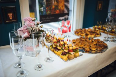 Masada şarap kadehleri olan bir yemek servisi tarafından güzel organize edilmiş açık büfenin yüzeysel bir fotoğrafı.