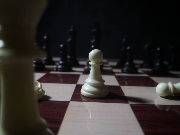 A white pawn on a chessboard on a blurred background
