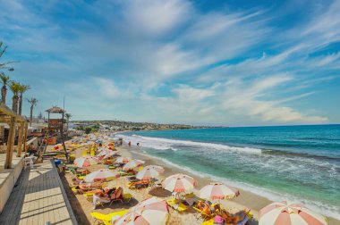 Hersonisos kasabası Girit 'te şemsiyeli ve turistli plaj