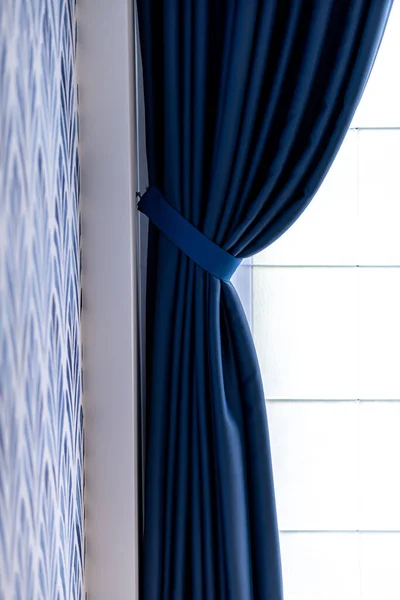 A vertical shot of blue blackout curtains in the living room