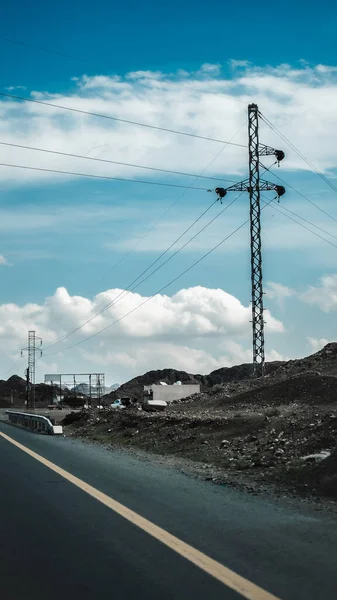 ภาพท สวยงามของถนนยางมะตอยสายไฟฟ าและภ เขาบน Sideroad ในเวลากลางว นภายใต องฟ าเมฆ — ภาพถ่ายสต็อก