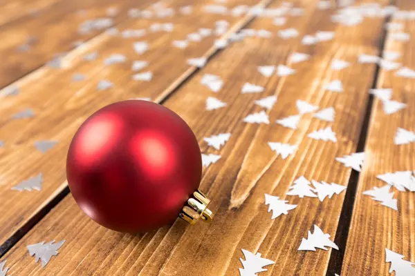 Ένα Κοντινό Πλάνο Ενός Κόκκινου Χριστουγεννιάτικου Παιχνιδιού Ένα Ξύλινο Τραπέζι — Φωτογραφία Αρχείου