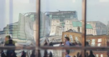 Gündüz vakti sokakta yürüyen kalabalığın görüntüsü aynaya yansıyor.