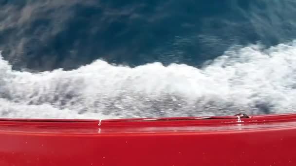 晴れた日に海の真ん中で赤いボートの動きに起因する波のトップショット — ストック動画