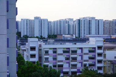 Yeşil ağaçlarla çevrili modern binaların olduğu bir yerleşim bölgesinin yüksek açılı görüntüsü.