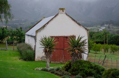 Tarlada eski beyaz bir kulübe.