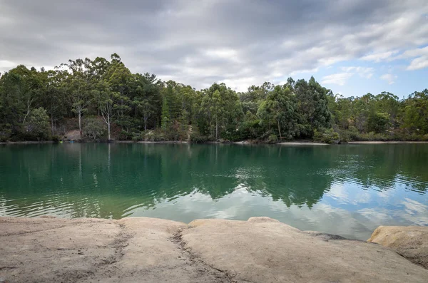 在一个阴郁的日子里 湖景映衬着岩石海岸 绿树成荫 — 图库照片