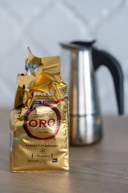 Lavazza Oro marka ve arka planda çaydanlık bulunan açık bir paketin dikey çekimi.