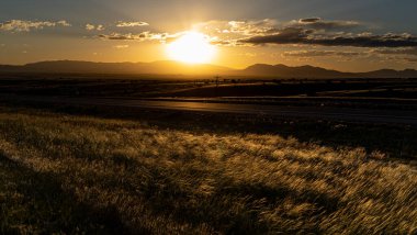 Gün batımında bir tarlanın ve dağların güzel manzarası