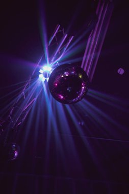 Kulüpteki parlak neon ışıklara karşı bir disko topunun dikey alçak açılı görüntüsü