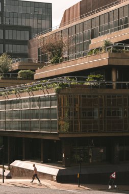 Bir sürü uzun pencereli, modern kahverengi bir binanın dikey görüntüsü.