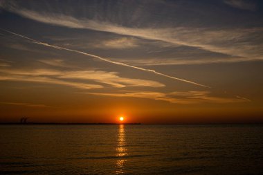 Denizin üzerindeki altın gün doğumunun büyüleyici görüntüsü.
