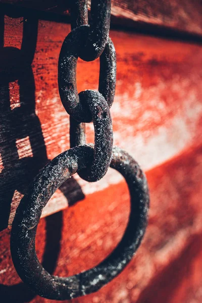 赤い背景に鉄の鎖の垂直ショット — ストック写真