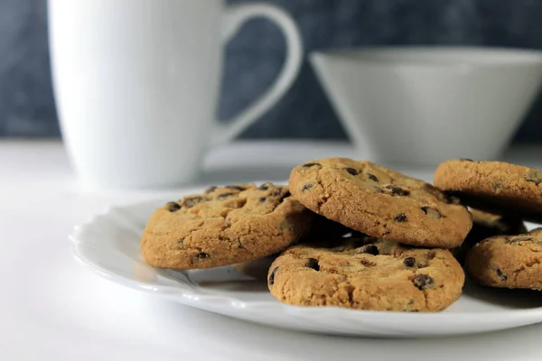 Close Biscoitos Chocolate Uma Placa Branca Xícara Leite Lado Dele — Fotografia de Stock