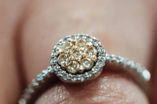 女性の指に丸い白と黄色の金の丸い婚約指輪の閉鎖 — ストック写真
