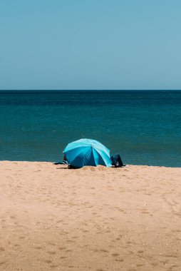 Portekiz, Algarve 'deki kumlu plajda bir şemsiyenin dikey çekimi.
