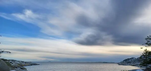 Vakker Utsikt Sjø Omgitt Klipper Skyet Himmel – stockfoto