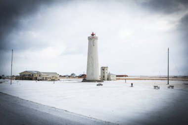 Karla kaplı arazinin ve İzlanda 'daki Gardur deniz fenerinin ürkütücü manzarası.