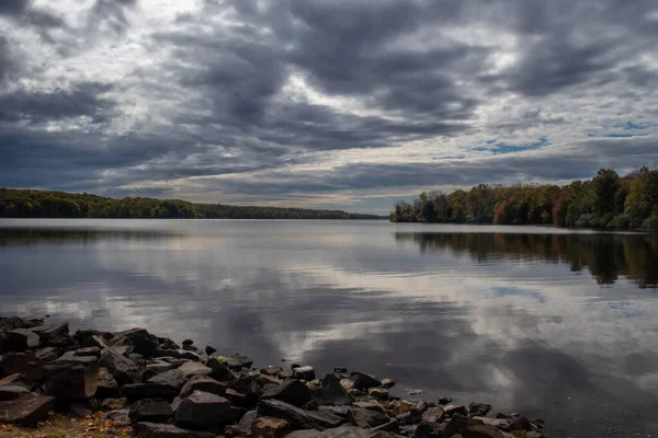 Fascynujący Widok Jesiennych Drzew Odbiciem Jeziorze Pod Bardzo Zachmurzonym Niebem — Zdjęcie stockowe