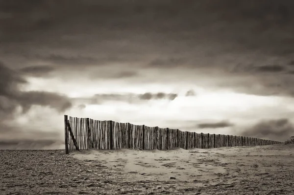 海滩上一道灰色的木制栅栏的照片 — 图库照片