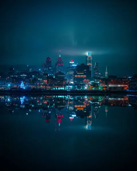 Een Verticaal Shot Van Een Verlichte Stad Skyline Nachts Weerkaatst — Stockfoto