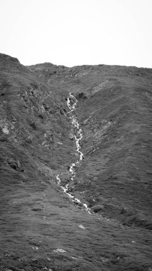 Dağlardaki küçük su akıntısının gri tonlu görüntüsü.
