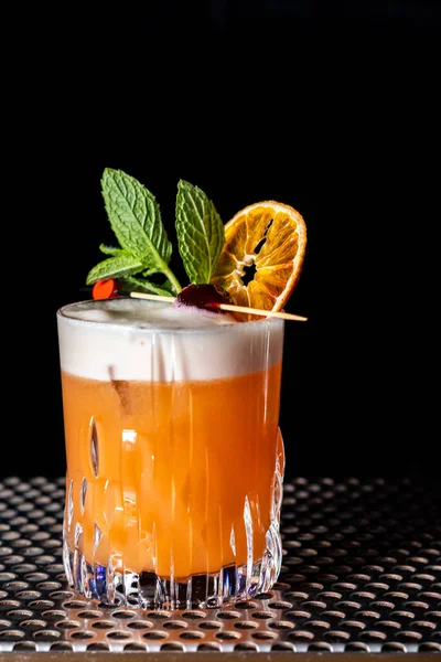 A vertical shot of a whiskey sour cocktail at a bar counter